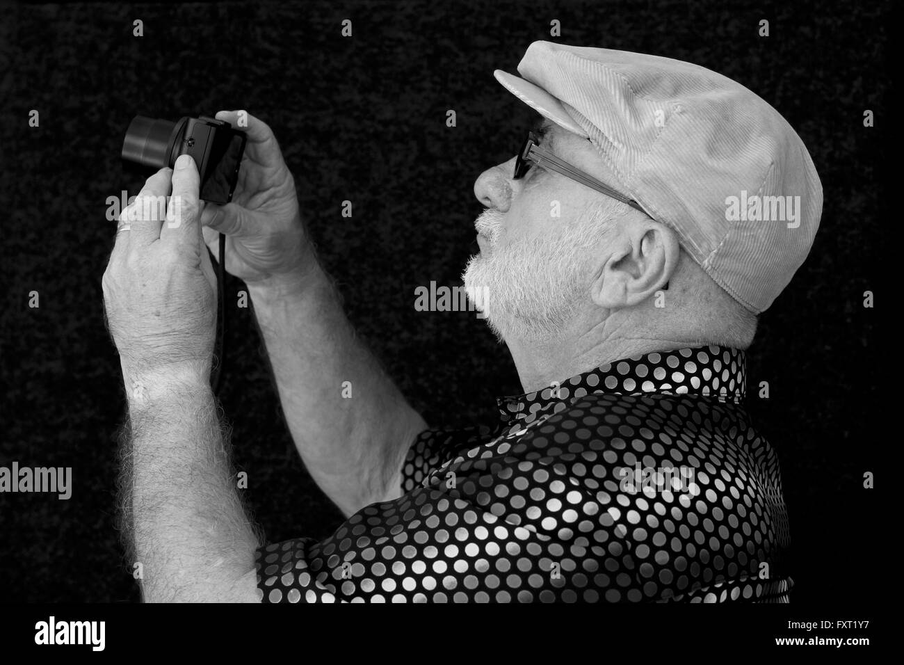 An old man with a camera in black and white. Stock Photo