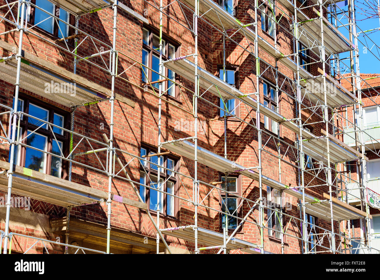 Lund, Sweden - April 11, 2016: Scaffoldings against a red brick apartment building being renovated. Stock Photo