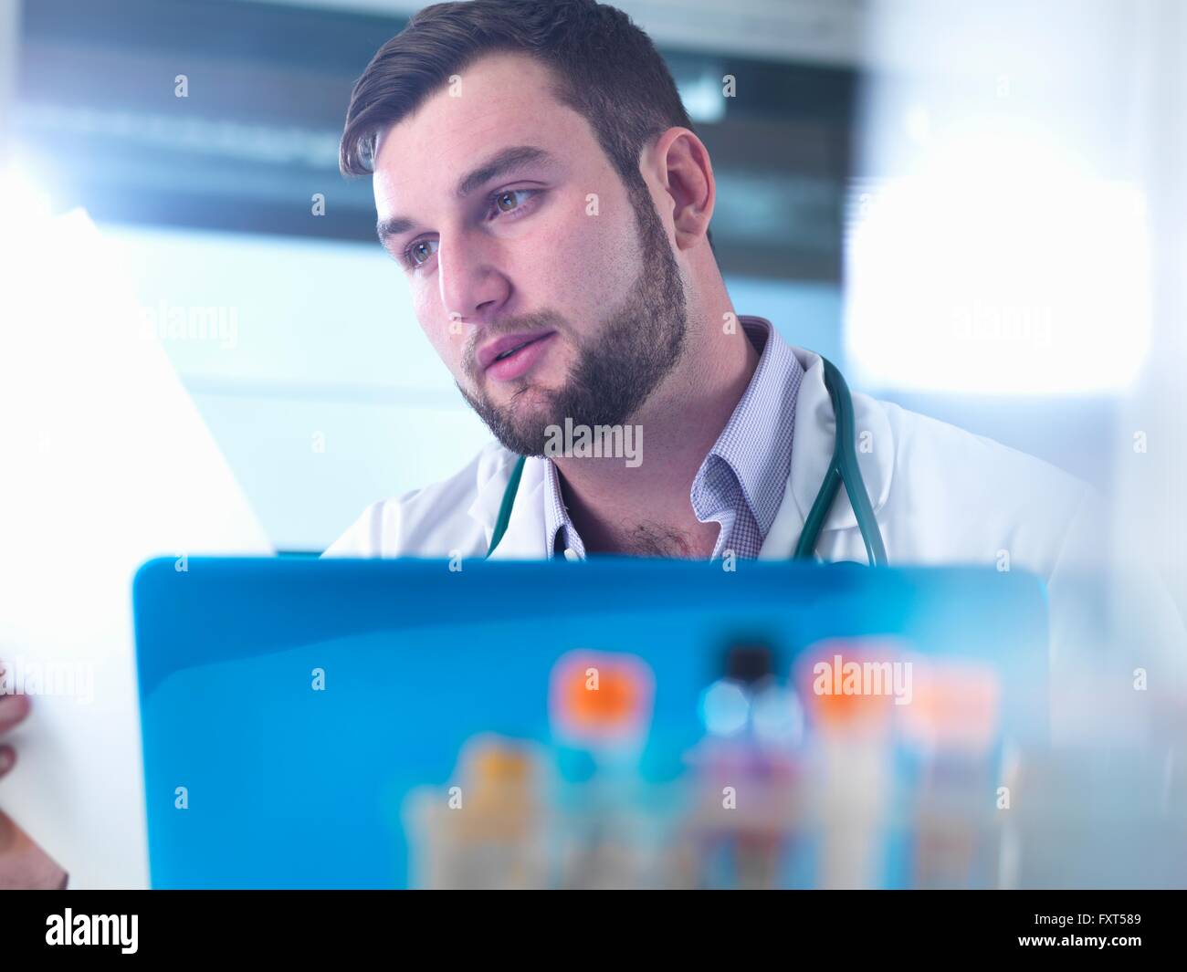 Doctor reading patient medical test results, samples in foreground