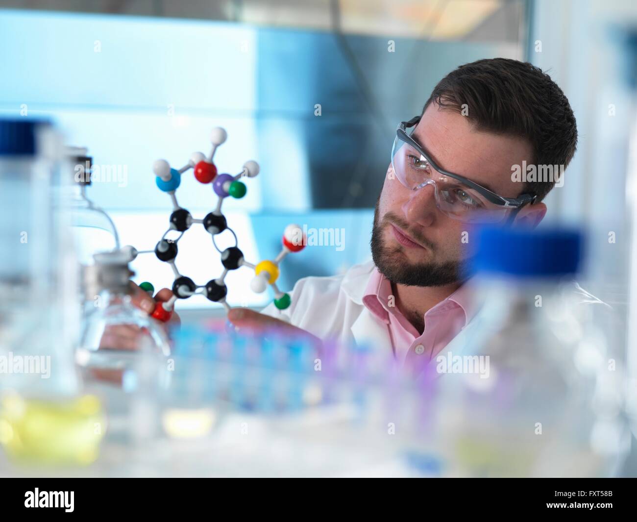 Scientist examining molecular model in laboratory Stock Photo