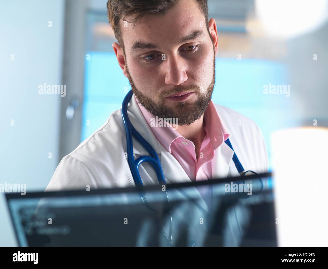 Junior doctor examining x-ray of fractured hand in hospital Stock Photo