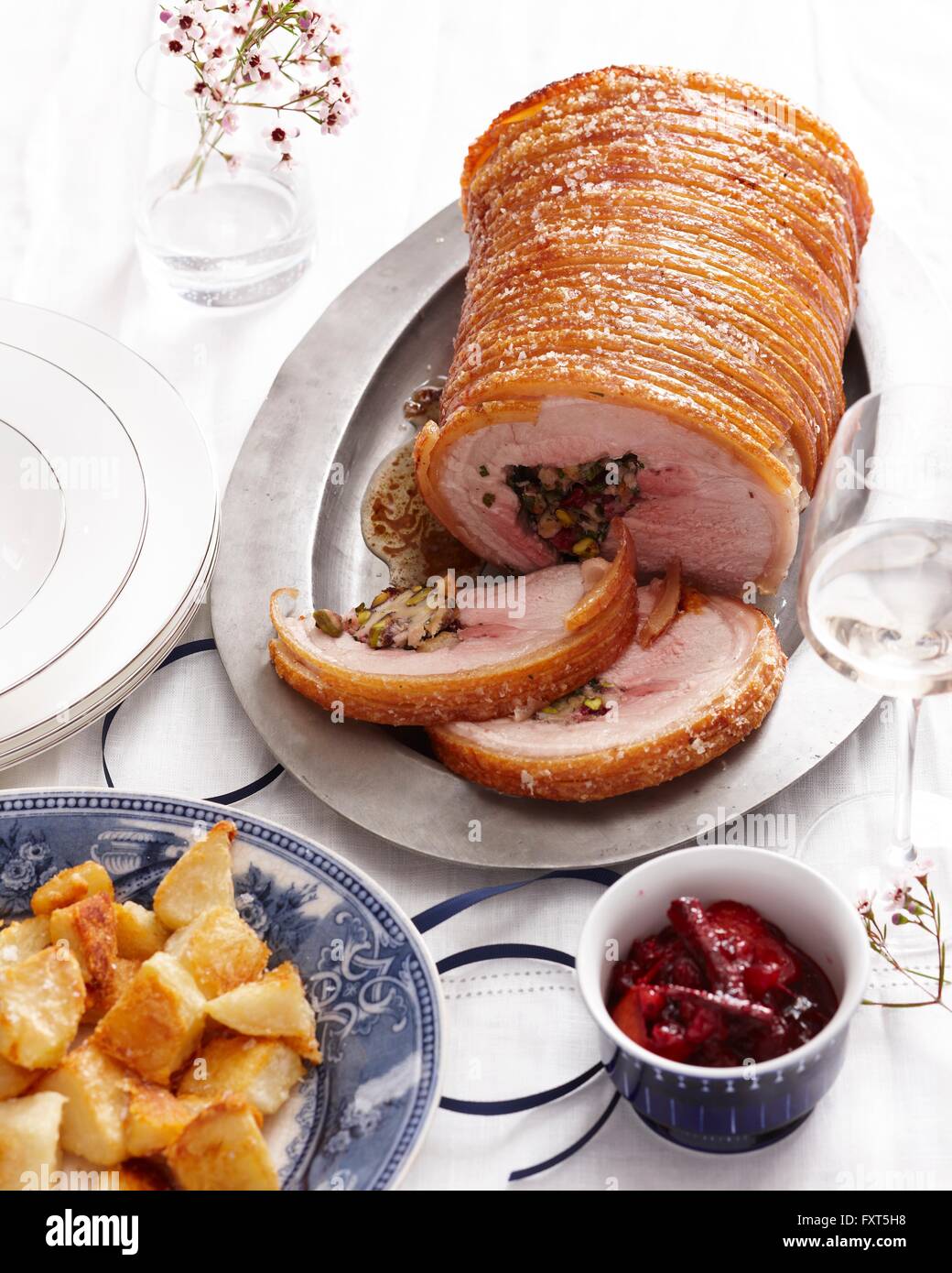 High angle view of stuffed roast pork joint with crispy crackling and roasted potatoes Stock Photo