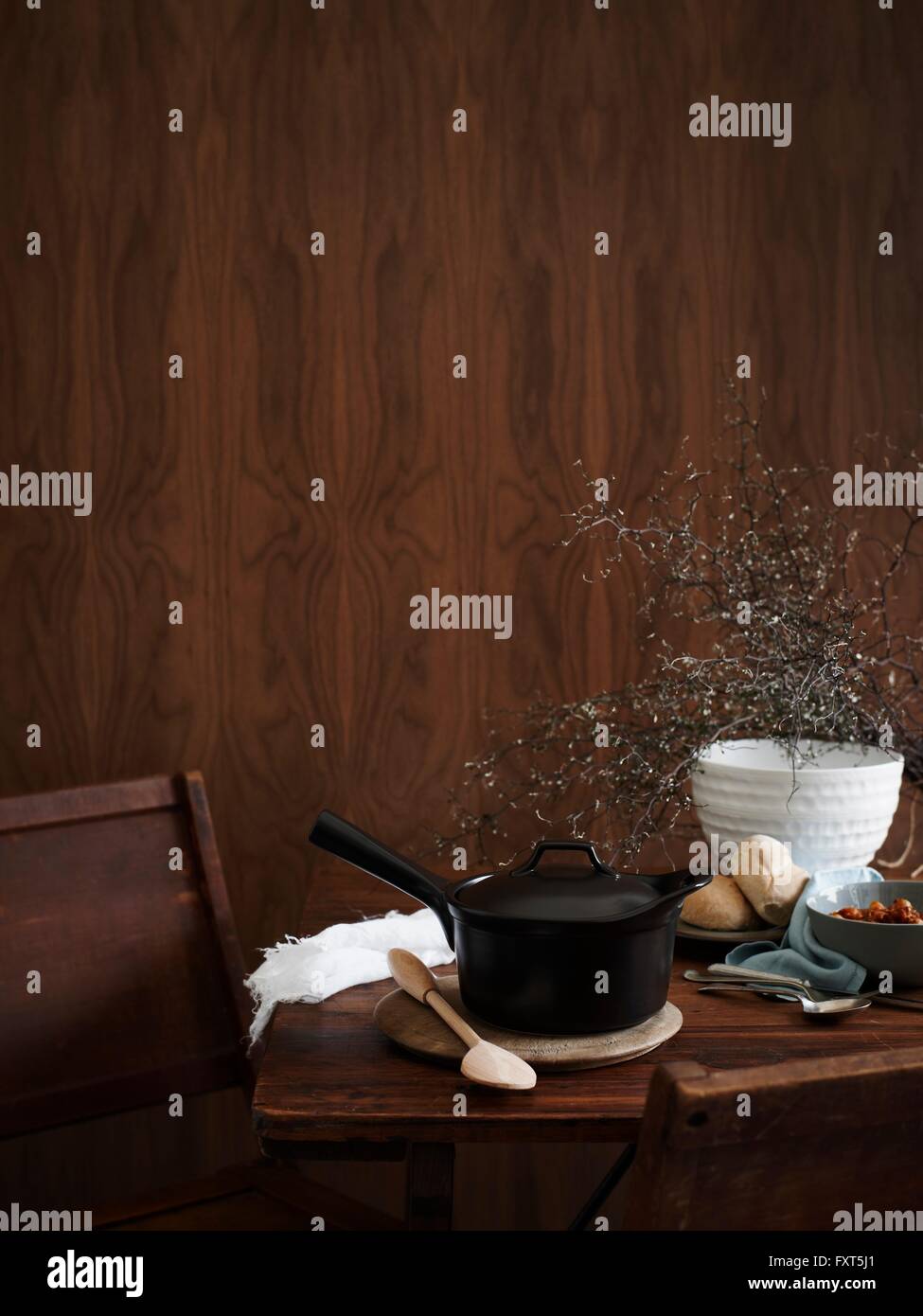 Saucepan on table with wooden spoon Stock Photo