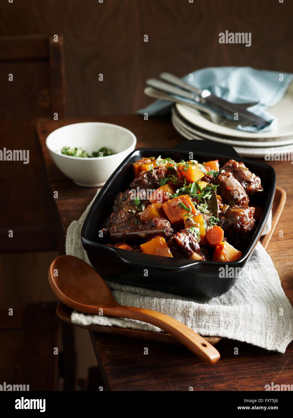 Middle eastern oxtail stew in serving dish with wooden serving spoon Stock Photo