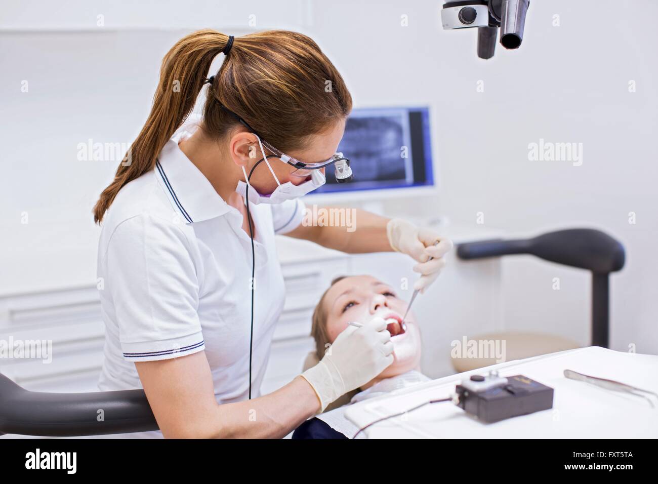 Dentist in dental clinic conducting dental examination on young woman Stock Photo Alamy