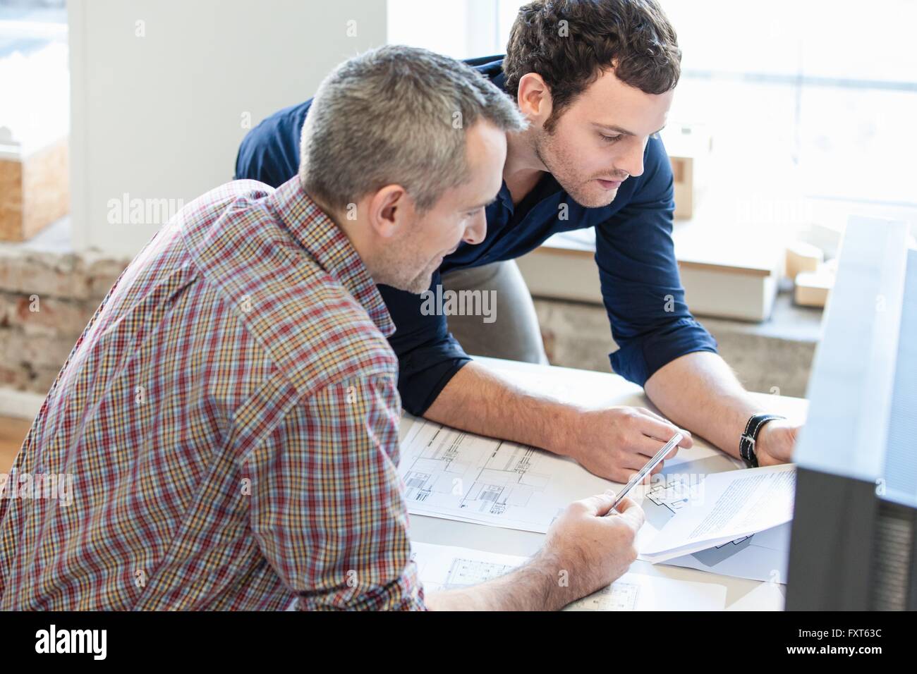 High angle view of men in office discussing paperwork Stock Photo