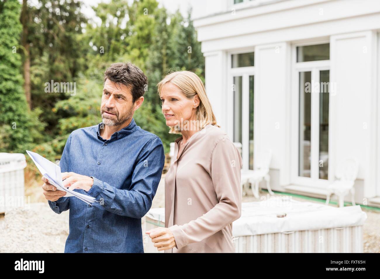 Architect discussing paperwork with homeowner looking away Stock Photo