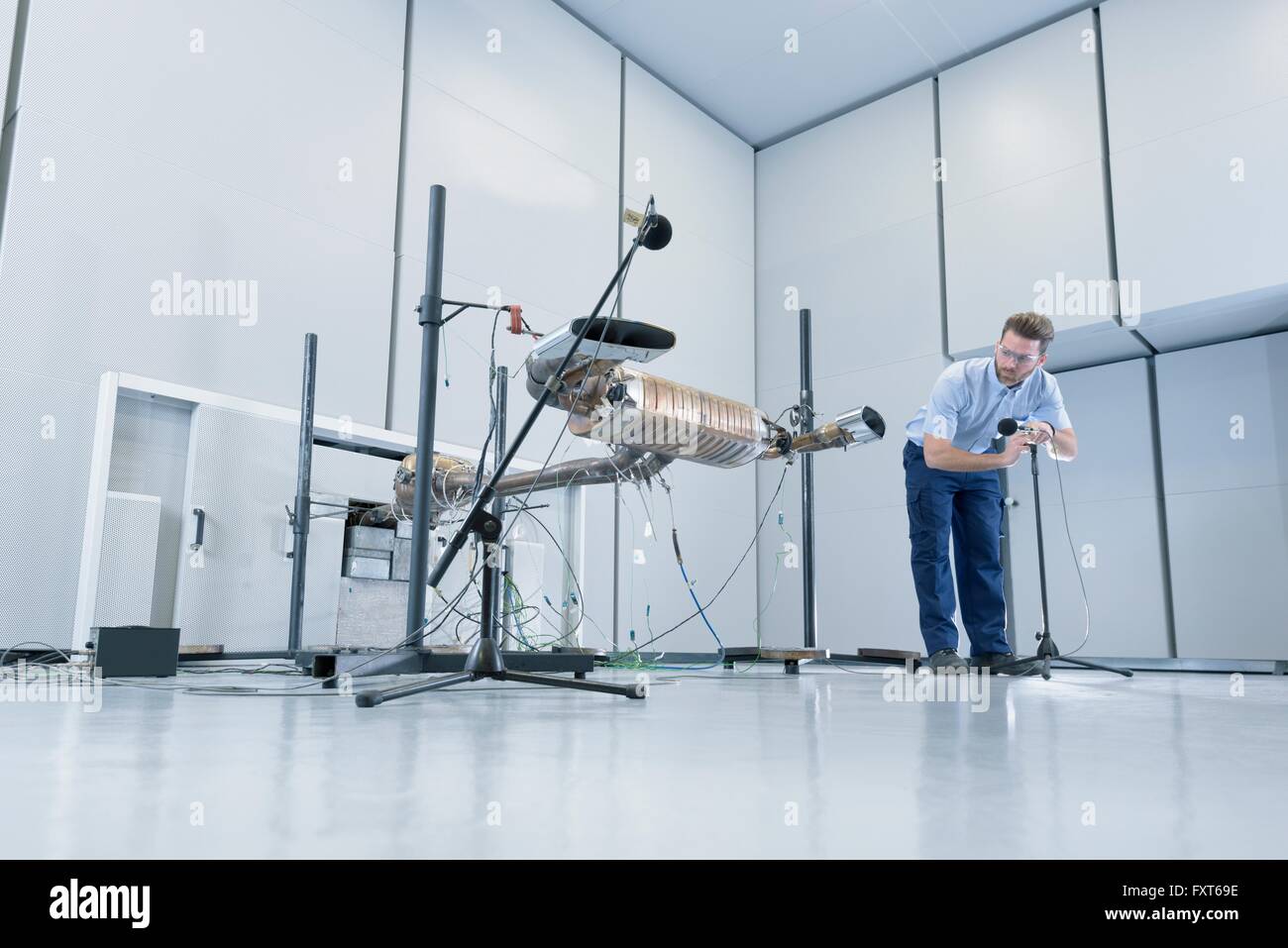 Engineer testing vehicle exhaust system in anechoic chamber Stock Photo
