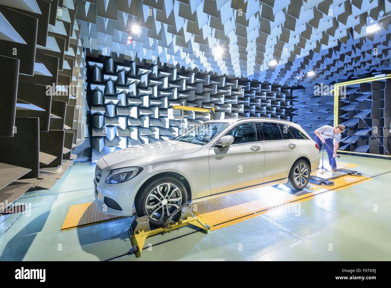 Engineer testing vehicle on rolling road in anechoic chamber Stock Photo