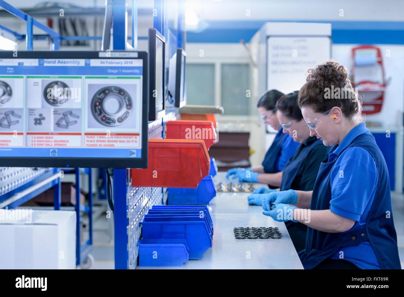 Female workers assembling parts in automotive parts factory Stock Photo