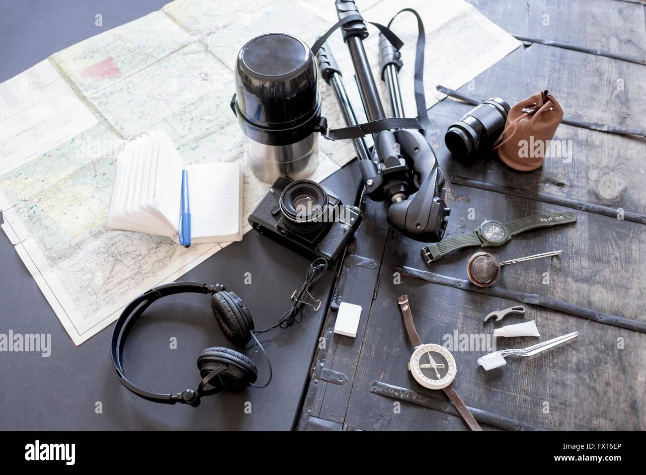 Overhead view of camera, accessories, map and notebook Stock Photo