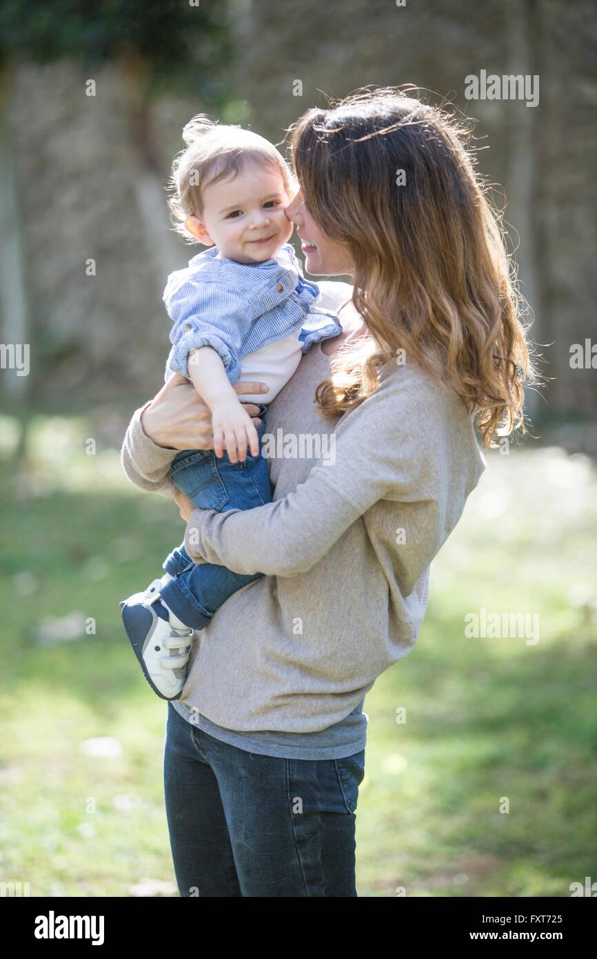 Mother holding smiling baby boy Stock Photo