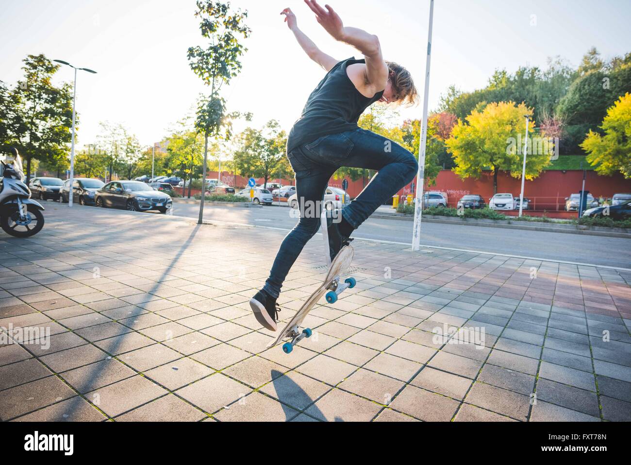 Young male urban skateboarder doing skateboarding jump trick on