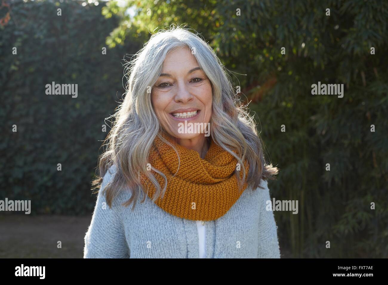 Portrait of woman with long gray hair looking at camera smiling Stock Photo