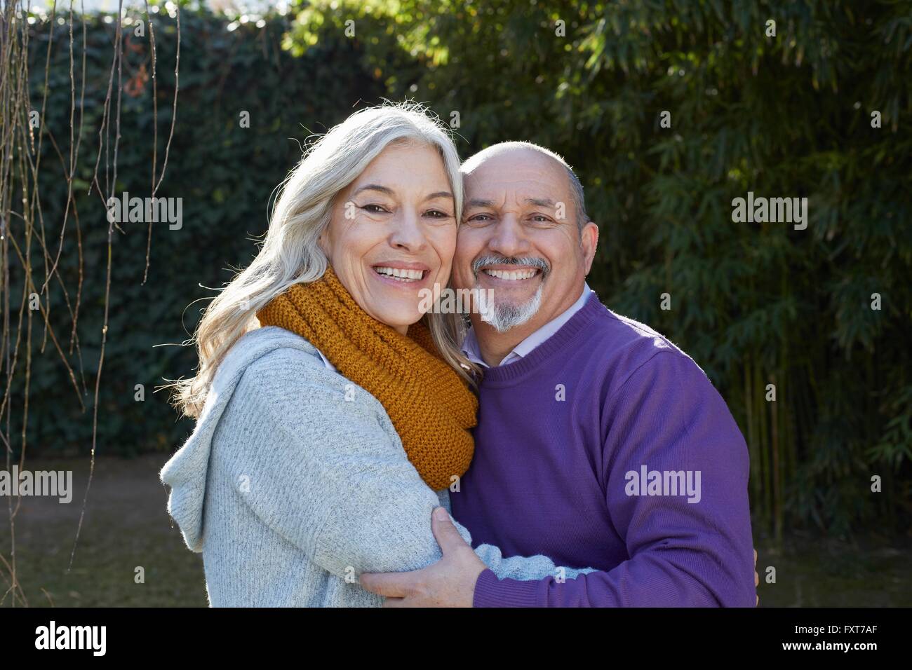 Mature couple hugging, looking at camera smiling Stock Photo