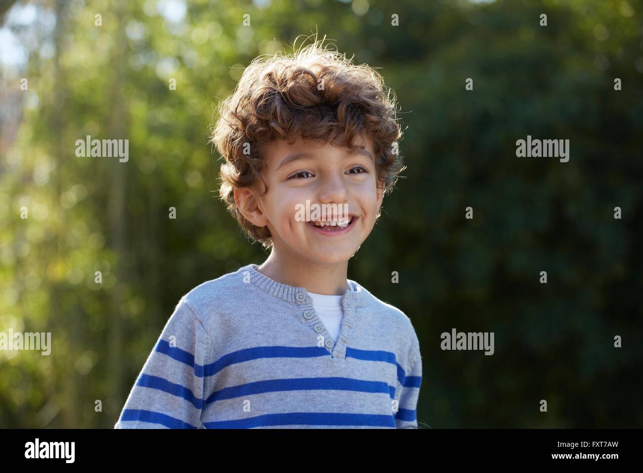 Portrait of curly haired boy looking away smiling Stock Photo