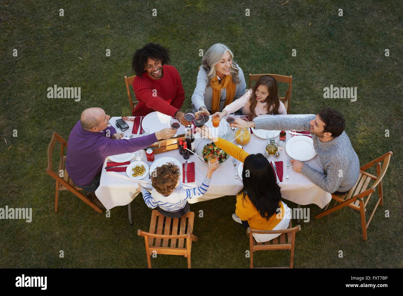 Overhead view of multi generation family dining outdoors, making a toast smiling Stock Photo
