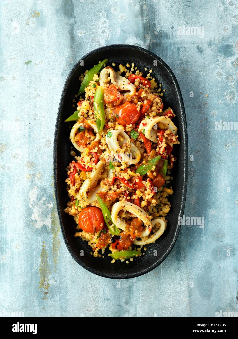 Zesty Sicilian squid, cherry tomatoes, green beans, couscous, red pepper Stock Photo