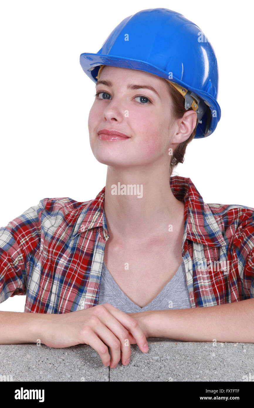 Female mason stood by unfinished  wall Stock Photo