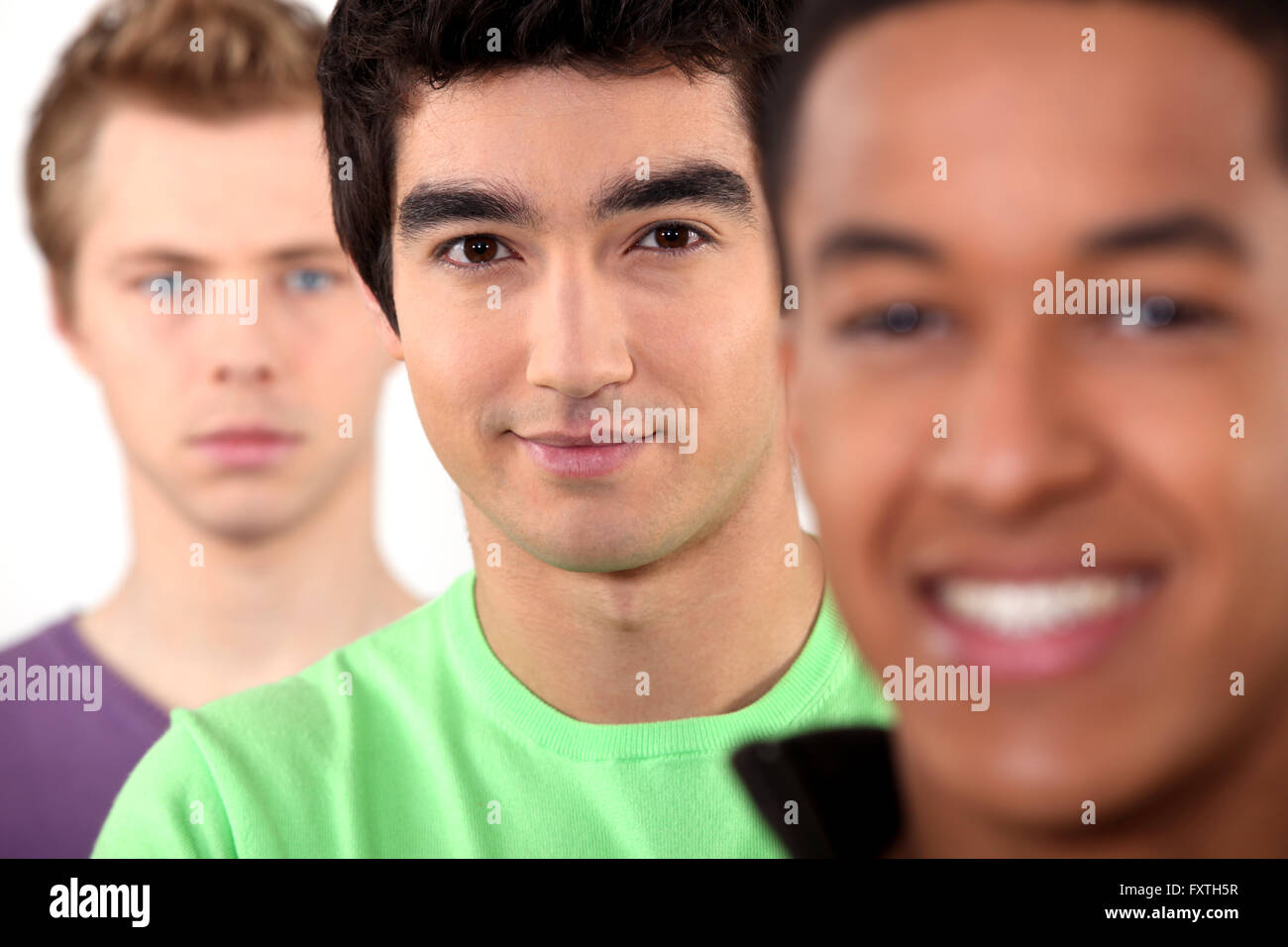 Three teenage men stood in a row Stock Photo - Alamy
