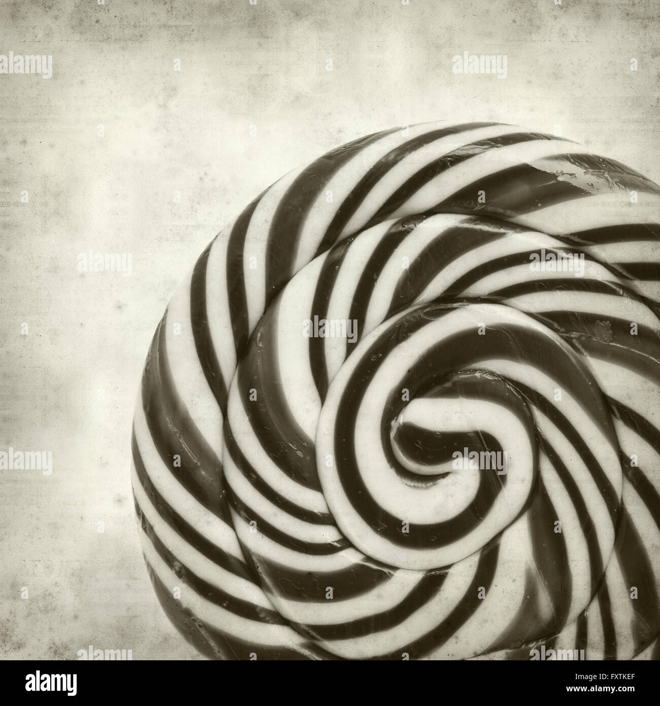 textured old paper background with large black and white swirl lolipop ...