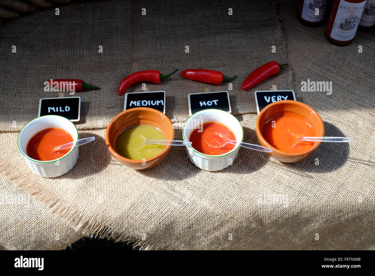 chilli sauces of various strengths for sale at a street market in southsea england uk Stock Photo