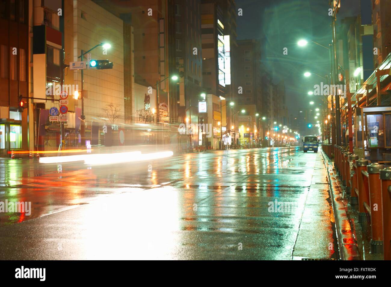 Wet city street and street lights at night, Tokyo, Japan Stock Photo