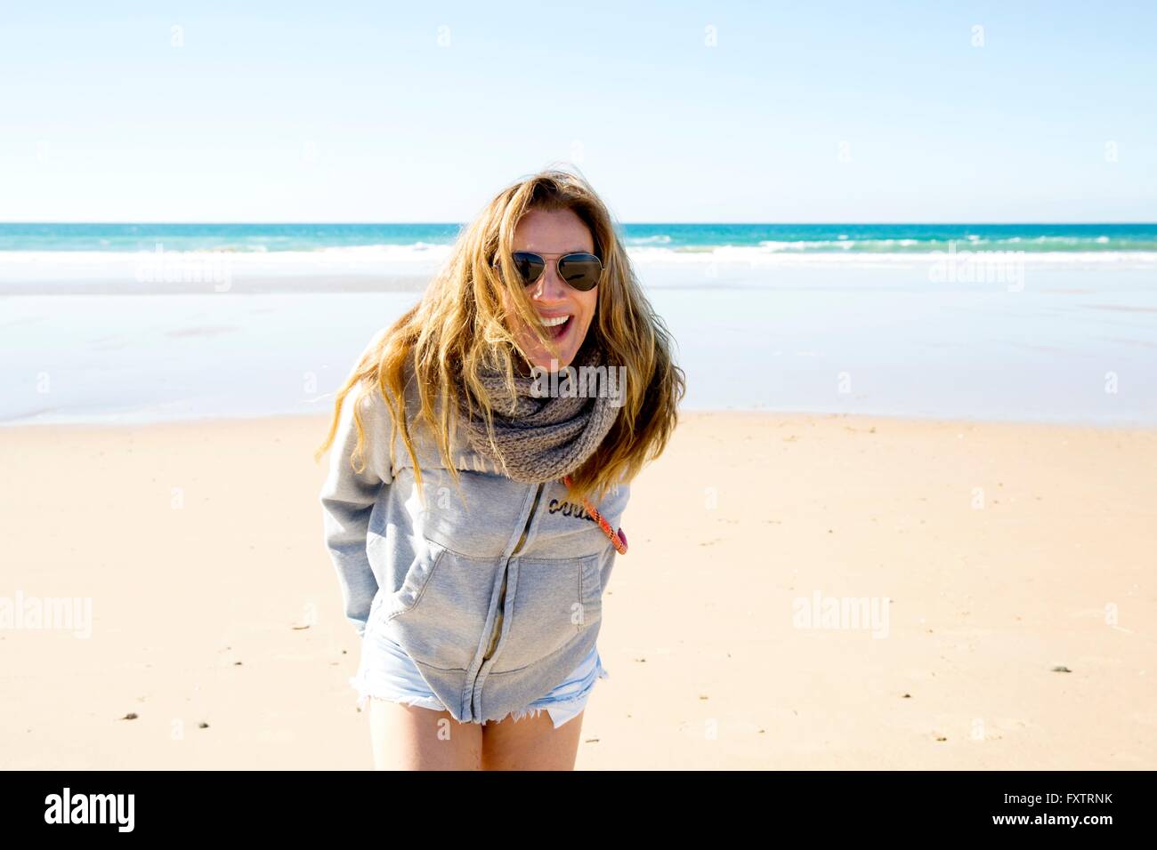 Portrait of mature woman with long blond hair on beach, Conil de la Frontera, Spain Stock Photo