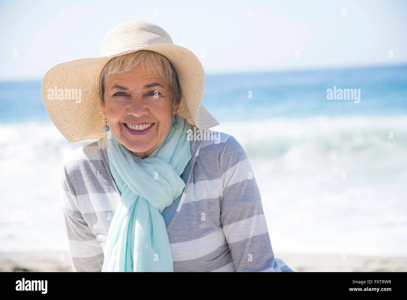Portrait of senior woman relaxing on beach, smiling Stock Photo - Alamy