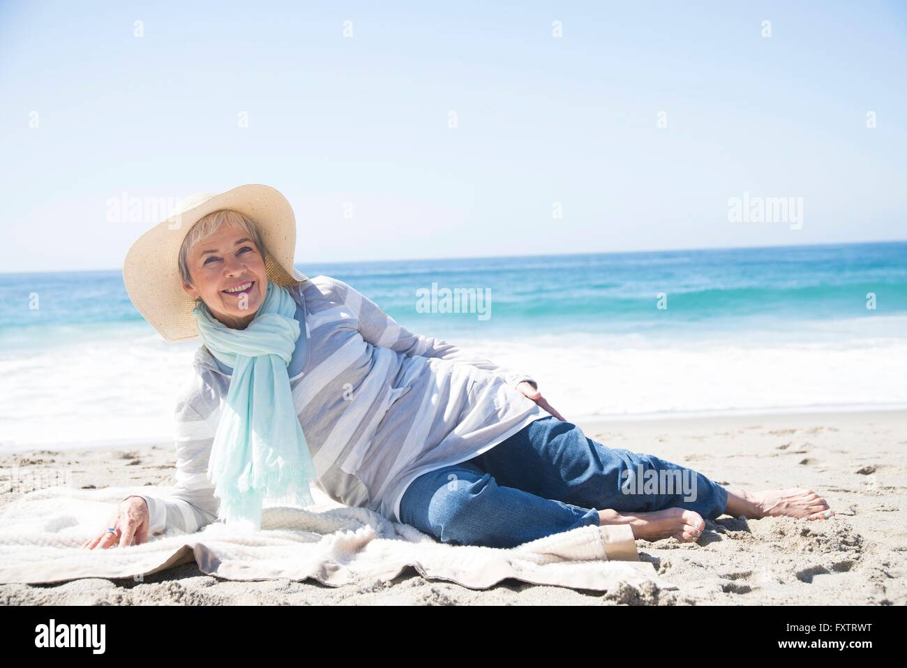 Portrait of senior woman relaxing on beach, smiling Stock Photo - Alamy
