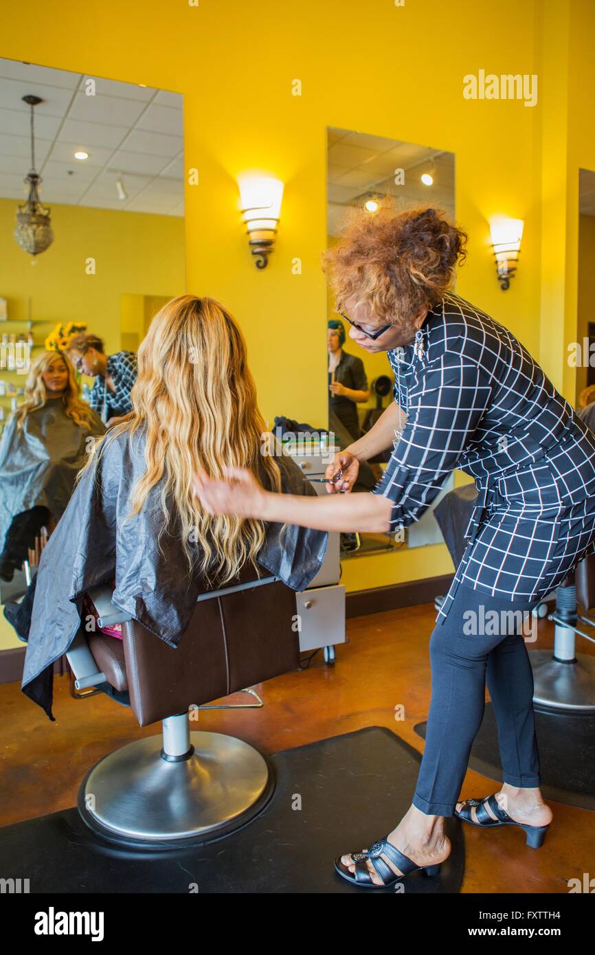 Stylist cutting woman's hair in hair salon Stock Photo