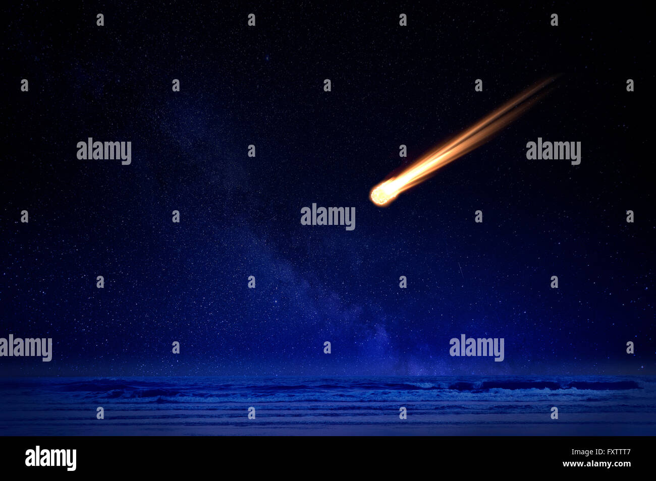 Meteor in night sky falling over ocean Stock Photo