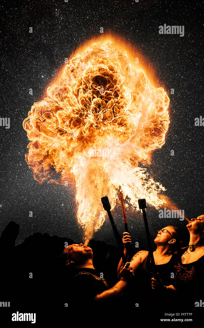 Performers fire breathing, starry night sky Stock Photo