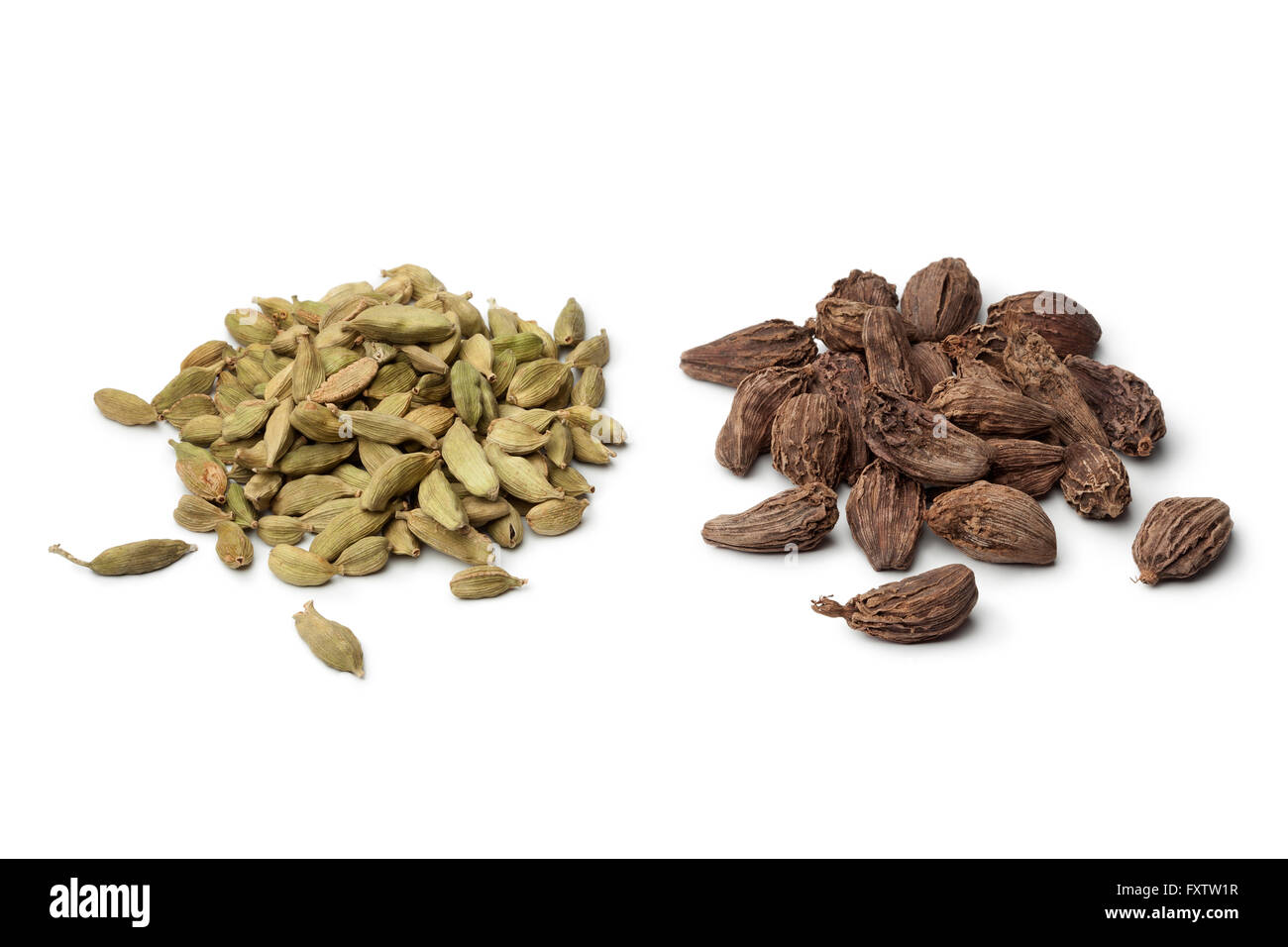 Heaps of green and large black Cardamom seeds on white background Stock Photo
