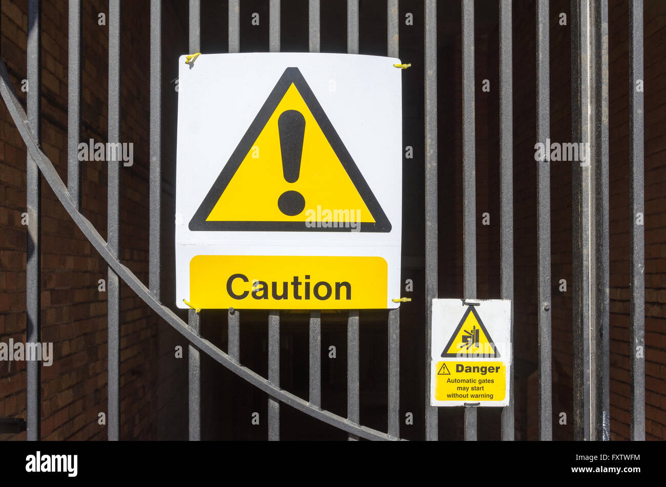 Caution warning sign on electrically operated gates Stock Photo - Alamy