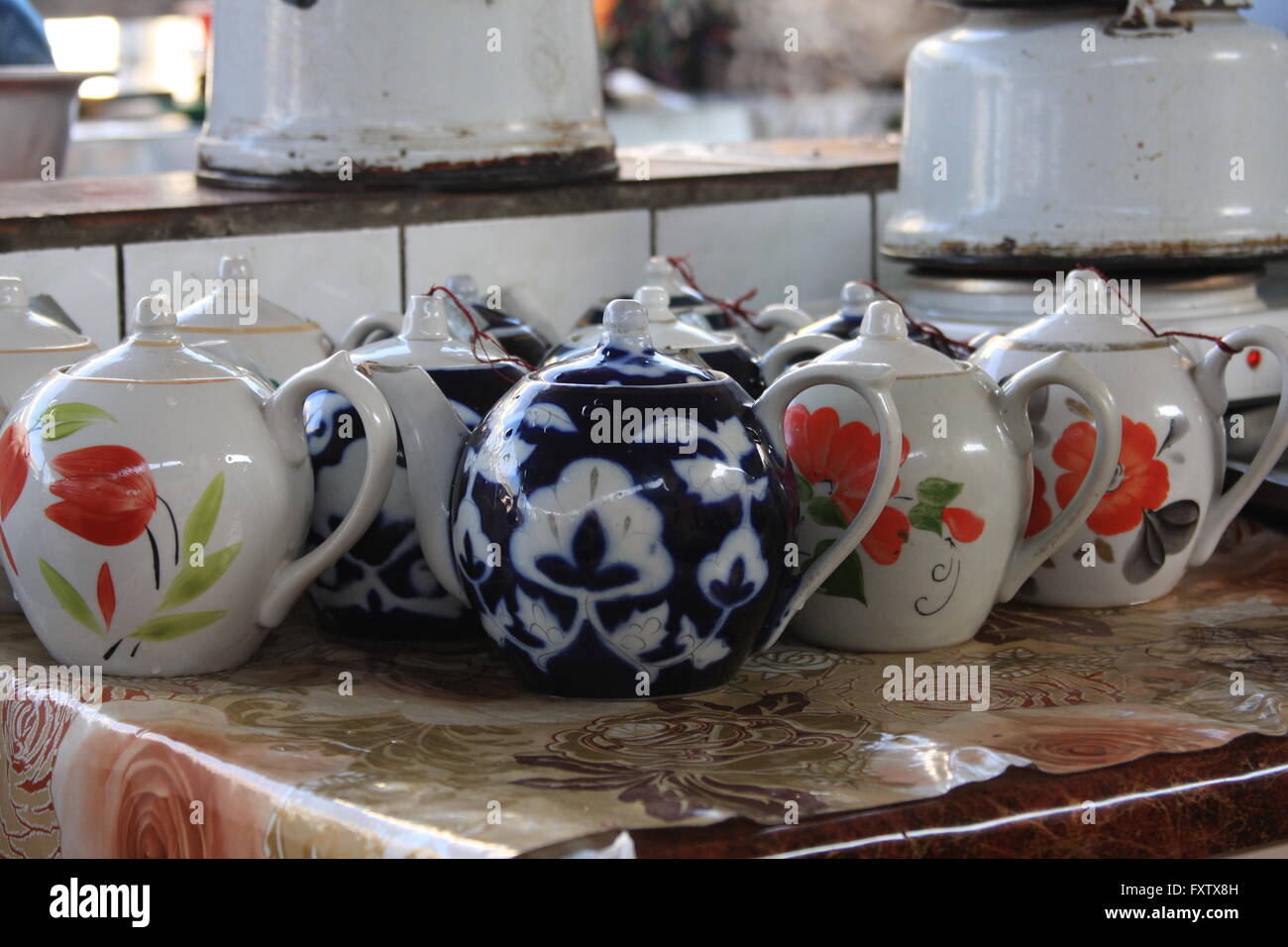 Teapots lined up, waiting to be served at a busy choyxana (teahouse) in Chorsu Bazaar.  Tashkent, Uzbekistan. Stock Photo