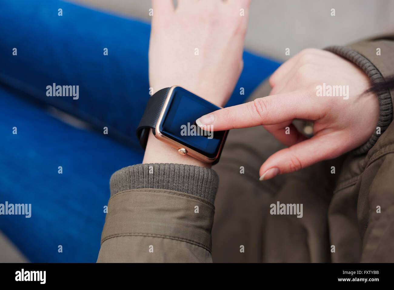 Hands of a woman using her smart watch. This new gadget lets you always stay connected to internet and social media networks from anywhere you want. Stock Photo