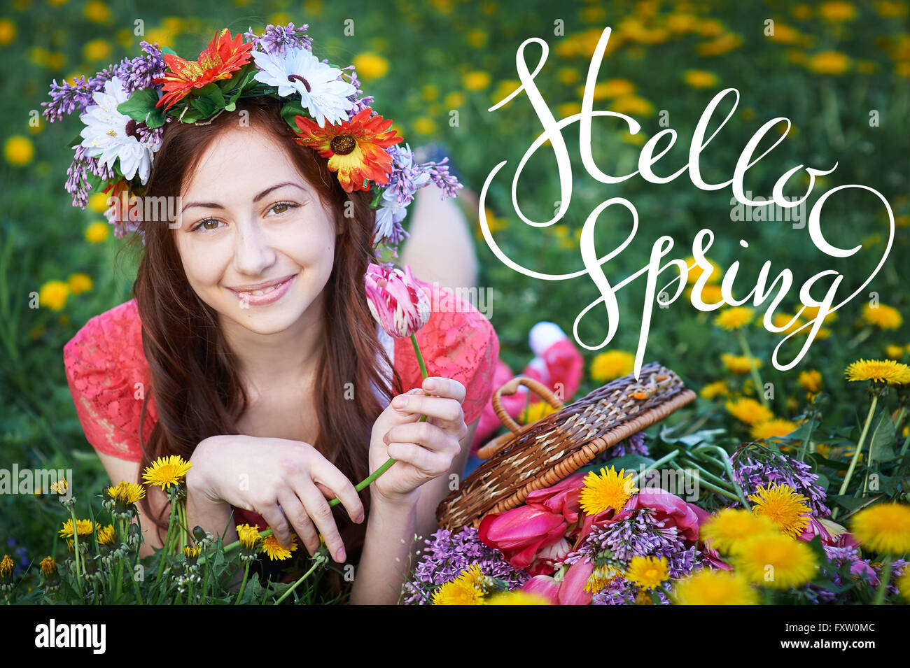young woman enjoying smell in a flowering spring garden with letters Hello sprint Stock Photo