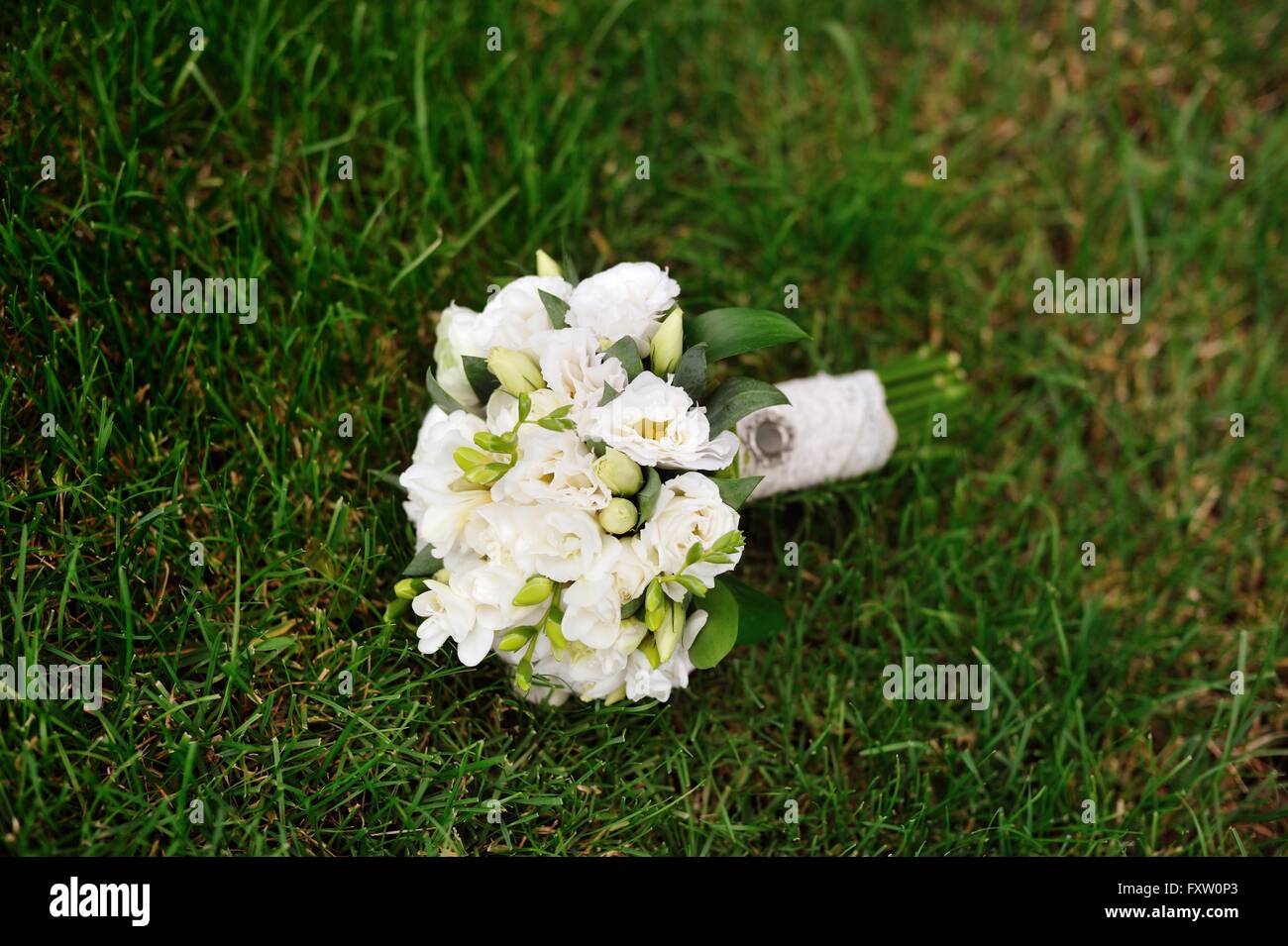 white bridal wedding bouquet on the green grass Stock Photo