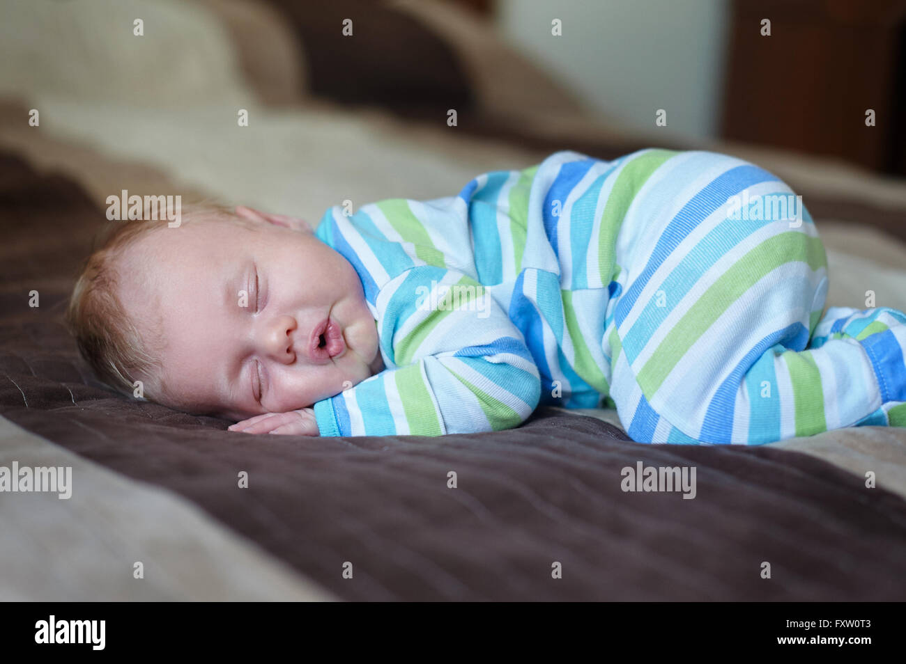Little baby sleeping on the bed in room Stock Photo