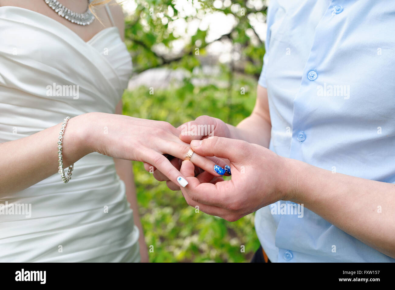bride groom dresses a wedding ring on her finger Stock Photo
