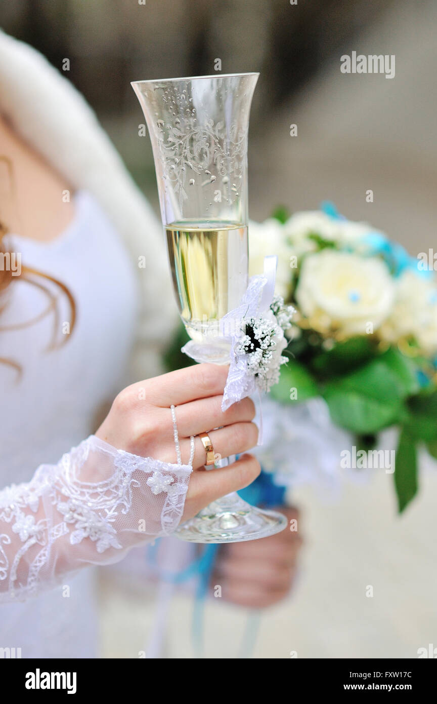 Bride is holding wedding bouquet and glass of champagne Stock Photo