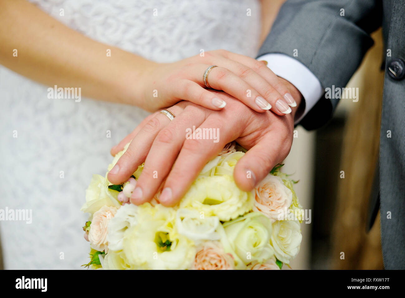hands of bride and groom on the bouquet roses Stock Photo - Alamy