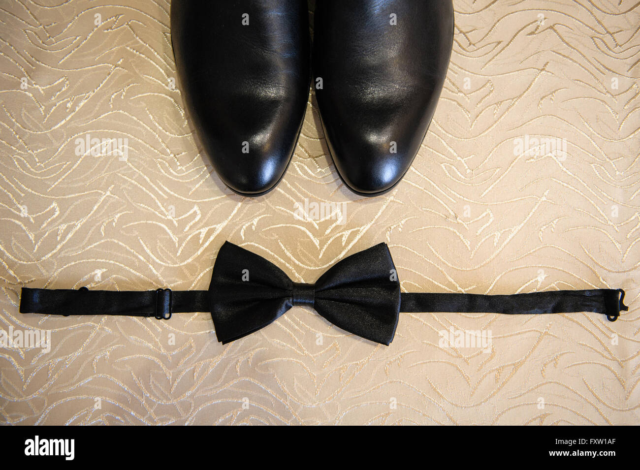 Shoes and bow tie lying on the wooden floor Stock Photo