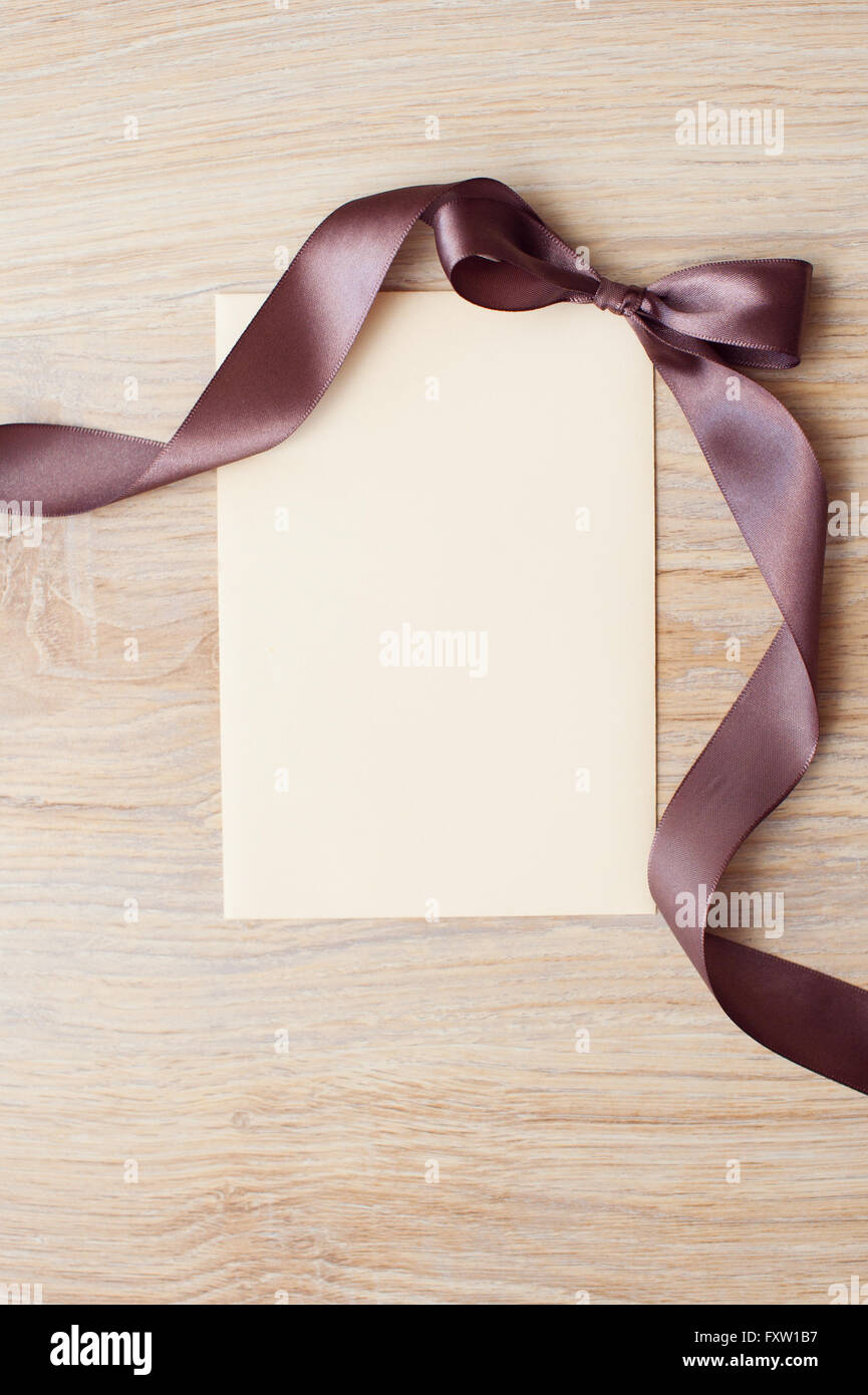 close up of card note with brown ribbon on white background Stock Photo