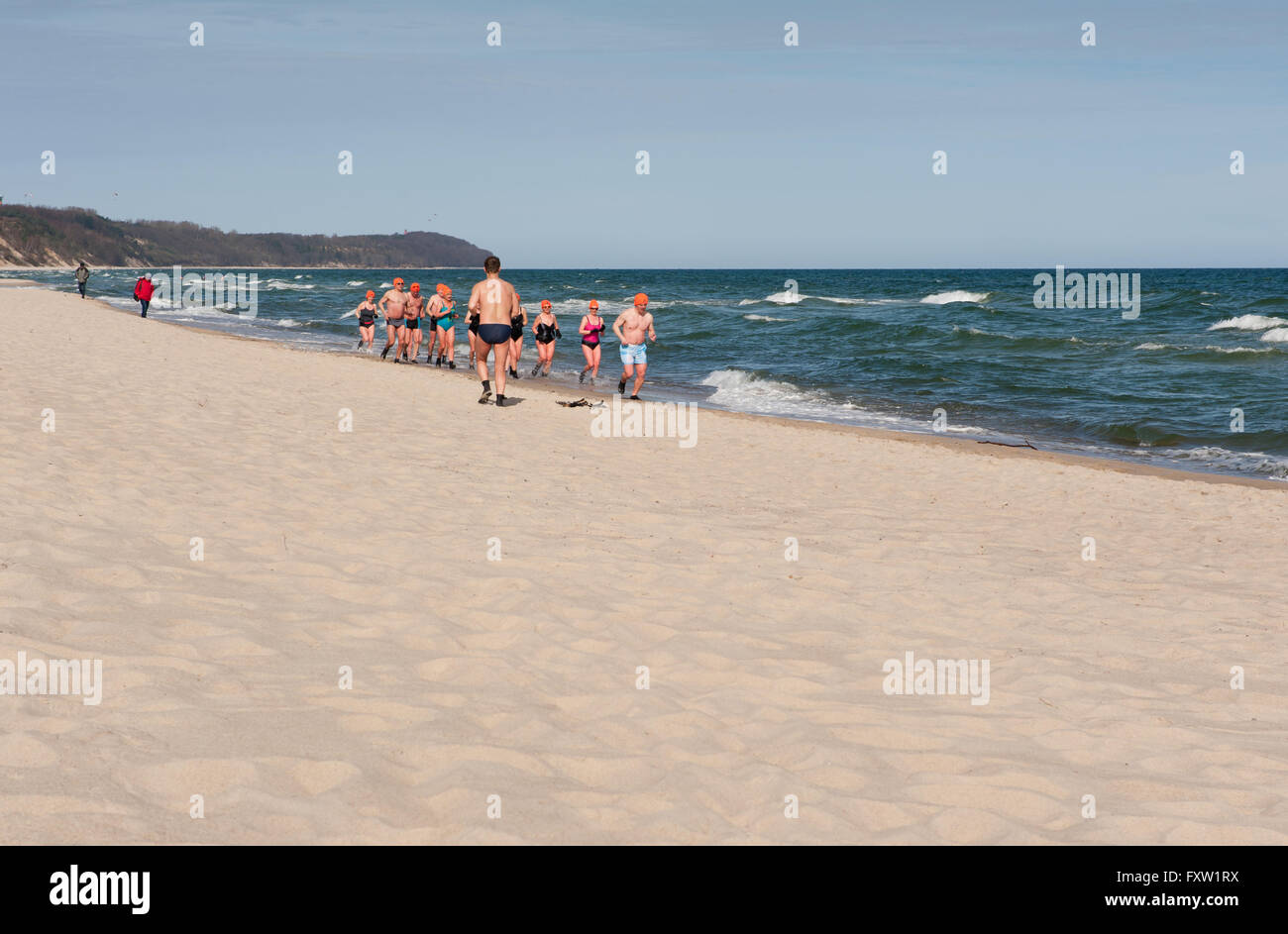 Winter swimmers running along the beach in Wladyslawowo seashore, Poland, Europe, people warming up, active sport in the Baltic Stock Photo