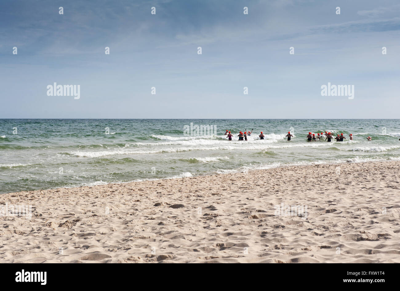 Winter swimmers in sea water in Wladyslawowo seashore, Poland, Europe, people during refreshing active sport on the Baltic Sea Stock Photo