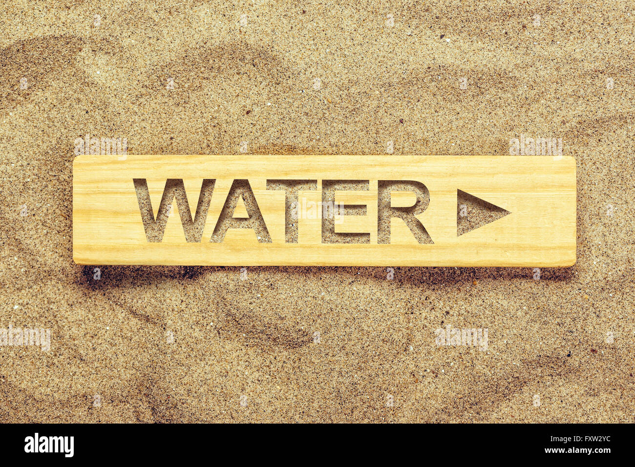 Water direction sign in dry desert sand, guide signpost for thirsty man. Stock Photo