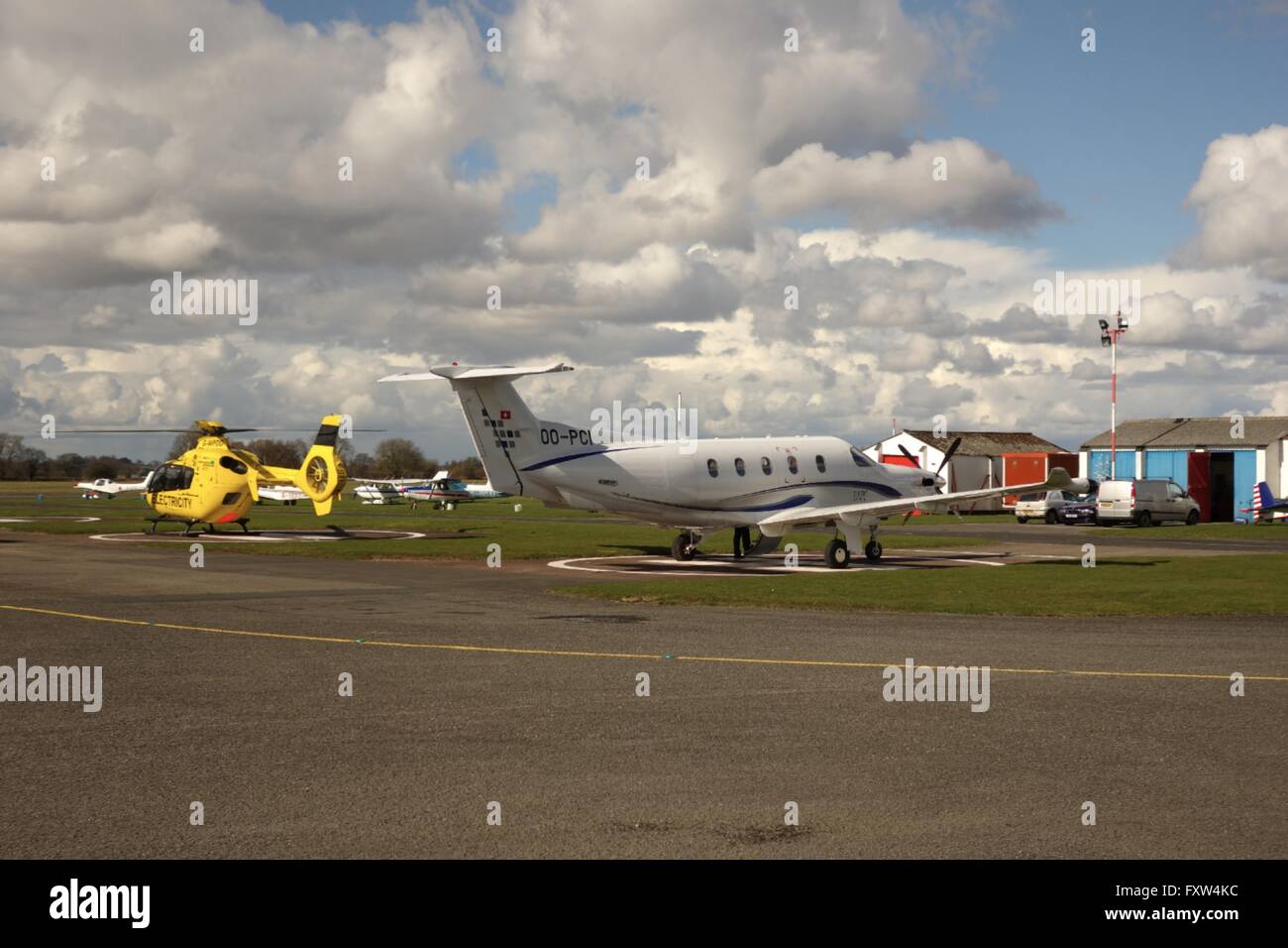 Large single engined aircraft and helicopter parked at Wolverhampton Halfpenny Green Airport, Staffordshire Stock Photo