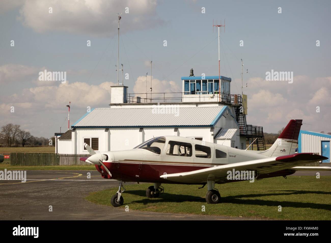 Light aircraft parked at Wolverhampton Halfpenny Green Aiirport with control tower in backgroundStaffordshire. UK Stock Photo